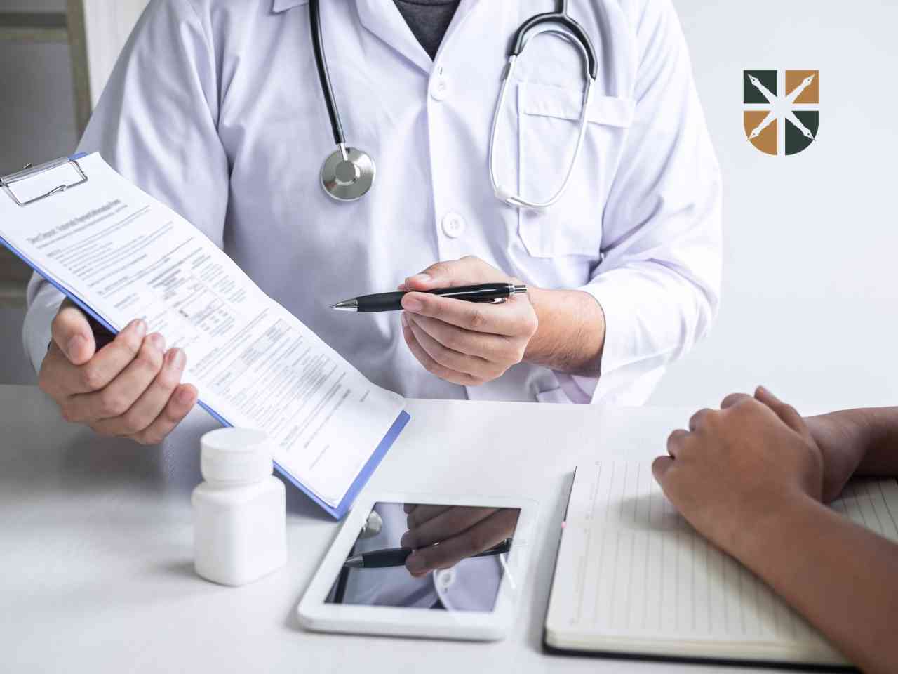 lekarz-tłumaczy-diagnozę Lekarz w białym fartuchu omawia dokumentację medyczną pacjenta wskazując długopisem na wyniki badań.
