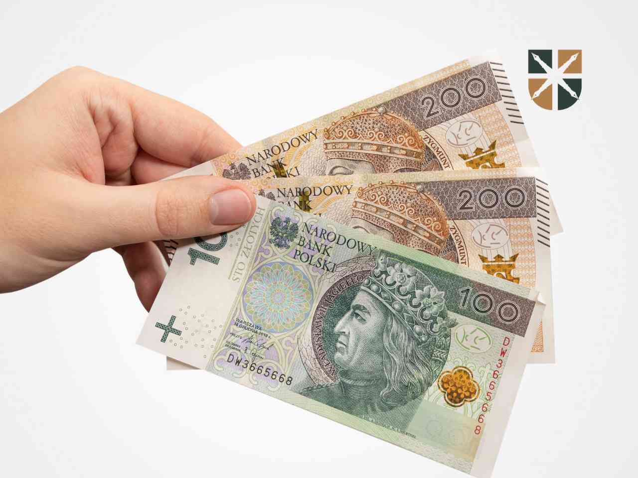 Dłoń trzymająca polskie banknoty o nominałach 100 i 200 złotych – symbol wypłaty odszkodowania powypadkowego.