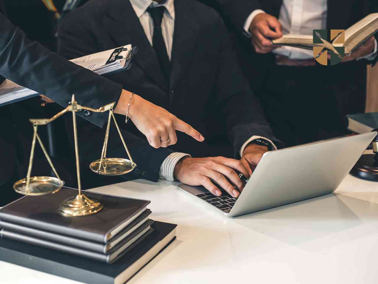 Prawnicy w garniturach analizują dokumenty i sprawdzają informacje na laptopie w kancelarii.