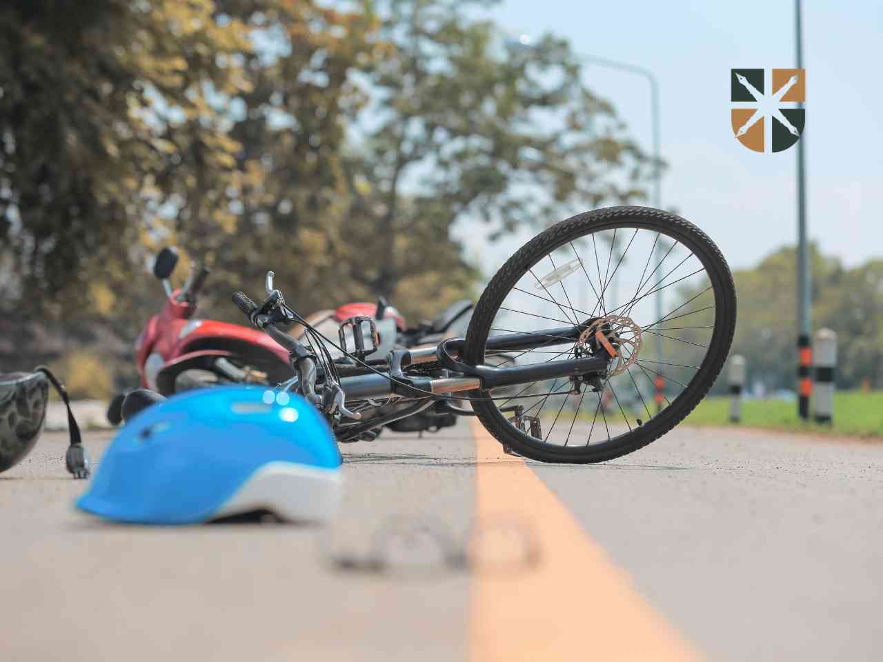 Przewrócony rower i motocykl leżące na asfalcie po wypadku drogowym – ilustracja kwestii ustalania winy.