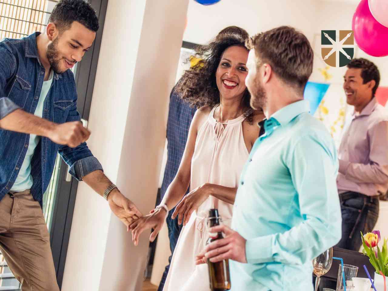 domowka Group of friends at a casual party smiling and chatting, one man and woman shake hands as others mingle in a bright home setting with balloons nearby