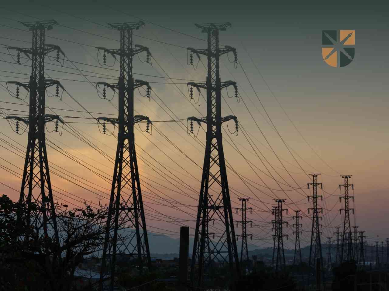 siec Wysokie słupy elektroenergetyczne na tle zachodu słońca, stanowiące element infrastruktury przesyłowej objętej małym wywłaszczeniem.