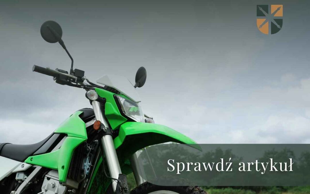 Green dirt bike on a grassy field with a dark overlay reading 'Sprawdź artykuł' inviting readers to read the article.