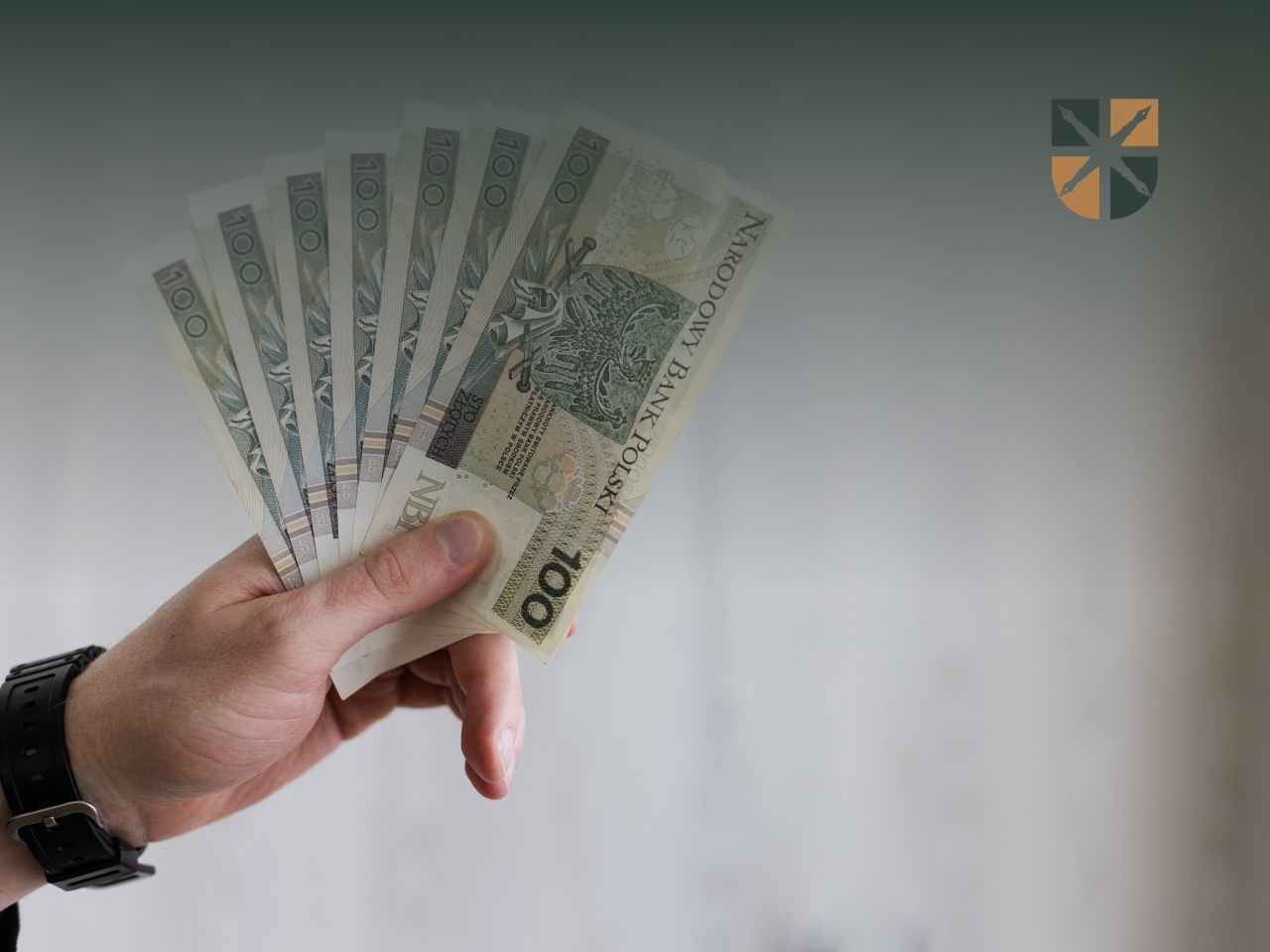 finanse-rozwod Dłoń trzymająca wachlarz banknotów stuzłotowych – ilustracja do podziału majątku po rozwodzie.
