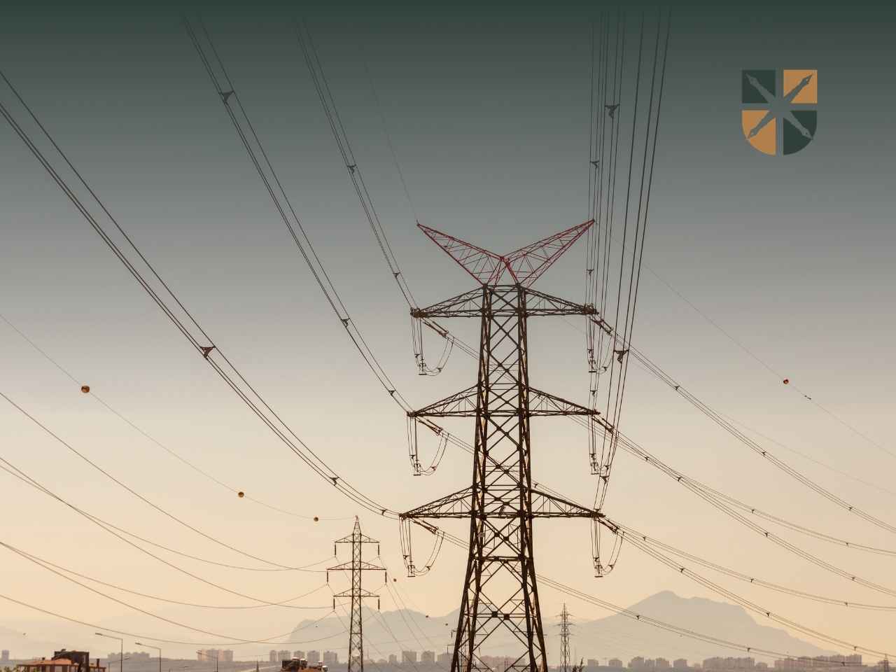 Stalowa kratowa wieża elektroenergetyczna z przewodami wysokiego napięcia przebiegająca przez działkę.