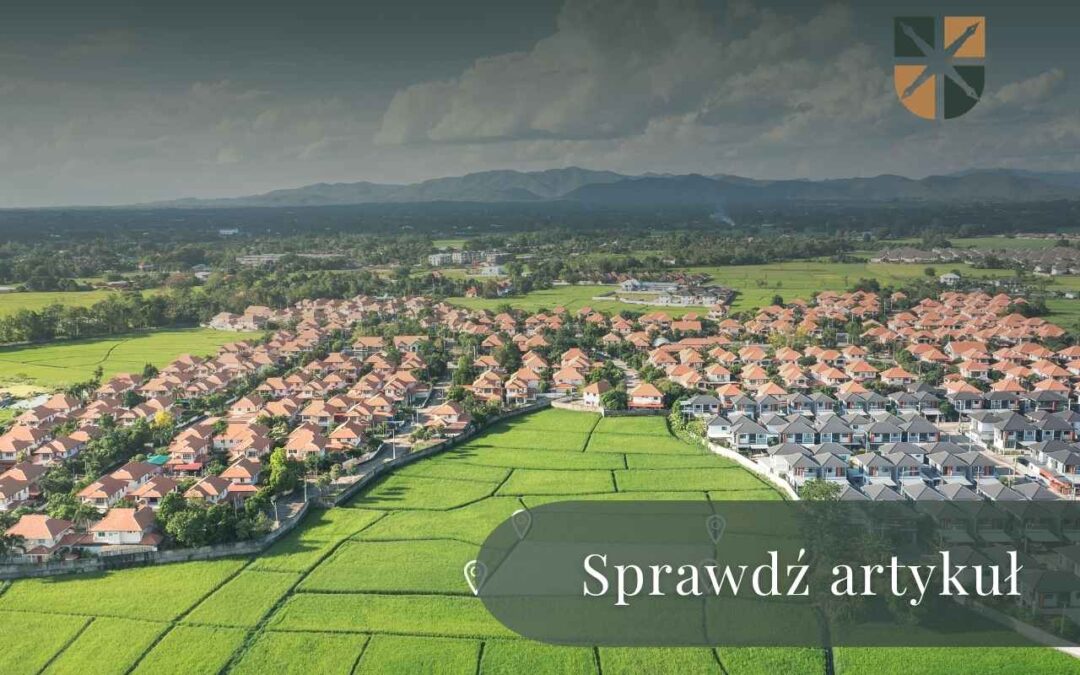 Panorama mniejszej miejscowości z lotu ptaka ukazująca zwarte osiedla i otaczające je tereny rolne.