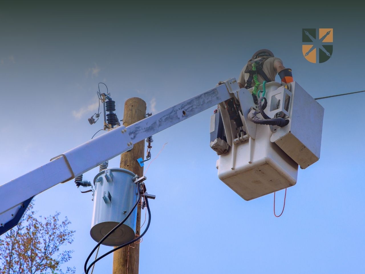 Pracownik pogotowia energetycznego w koszu podnośnika naprawia linię zasilającą na słupie.