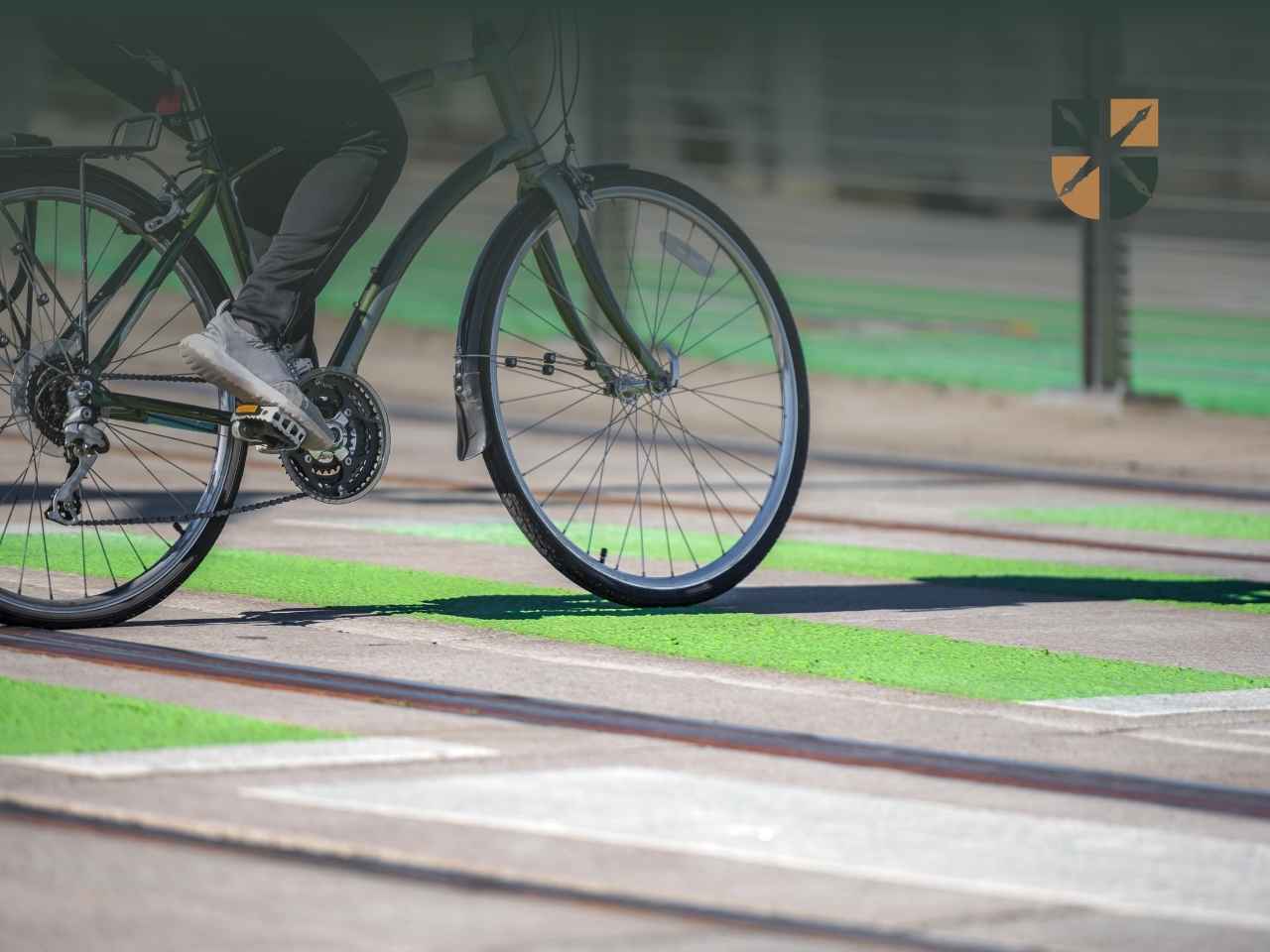 przejazd-rowerowy Rowerzysta przejeżdża rowerem przez zielony przejazd rowerowy i tory tramwajowe.