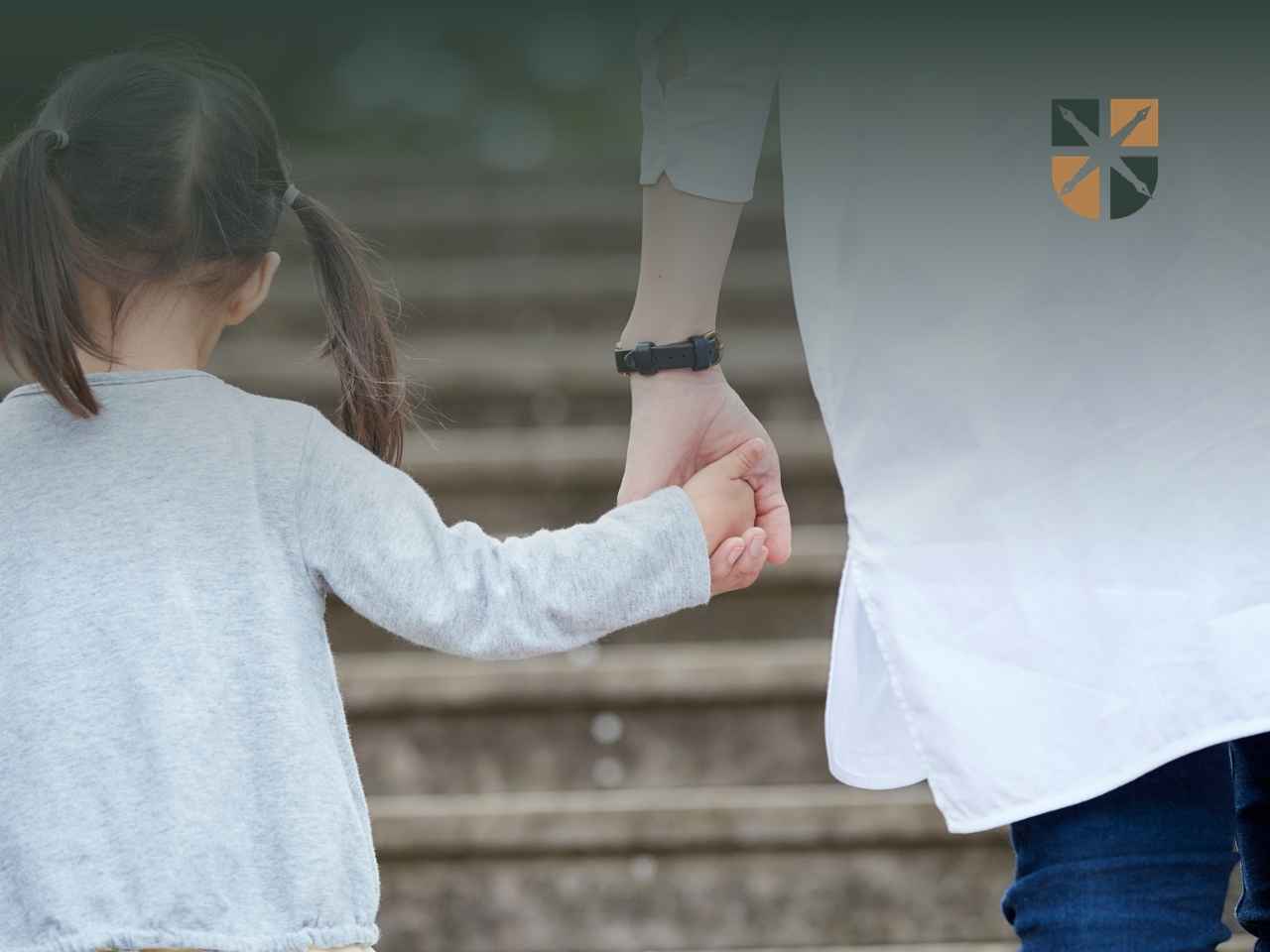 spacer-z-dzieckiem Opiekun trzyma dziecko za rękę podczas wchodzenia po schodach – kwestia opieki nad dzieckiem po rozstaniu.