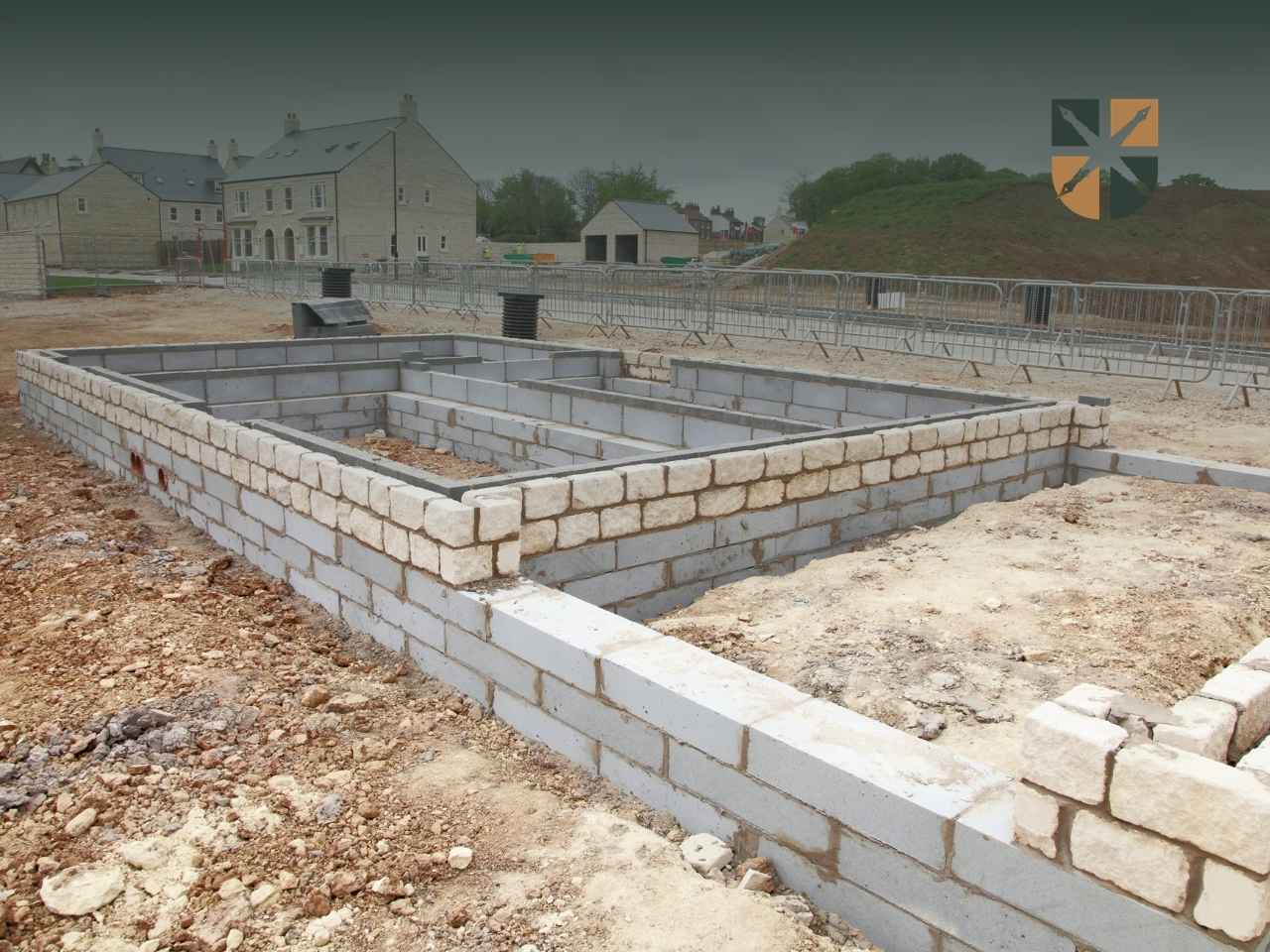 dzialka-budowlana-pog Wykop i murowane fundamenty budynku na działce budowlanej przygotowanej pod inwestycję.