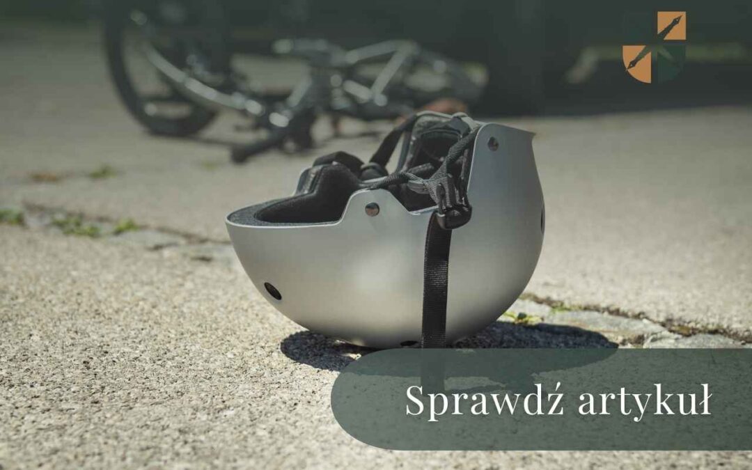 Szary kask rowerowy leżący na asfalcie obok powalonego roweru – artykuł o odszkodowaniach.