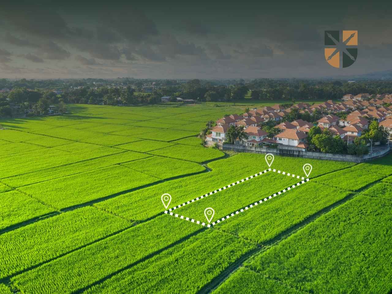 Działka budowlana wyznaczona przerywaną linią na tle zielonego pola i osiedla domów